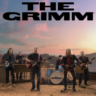 Band 'The Grimm' performing outdoors with a colorful sky in the background