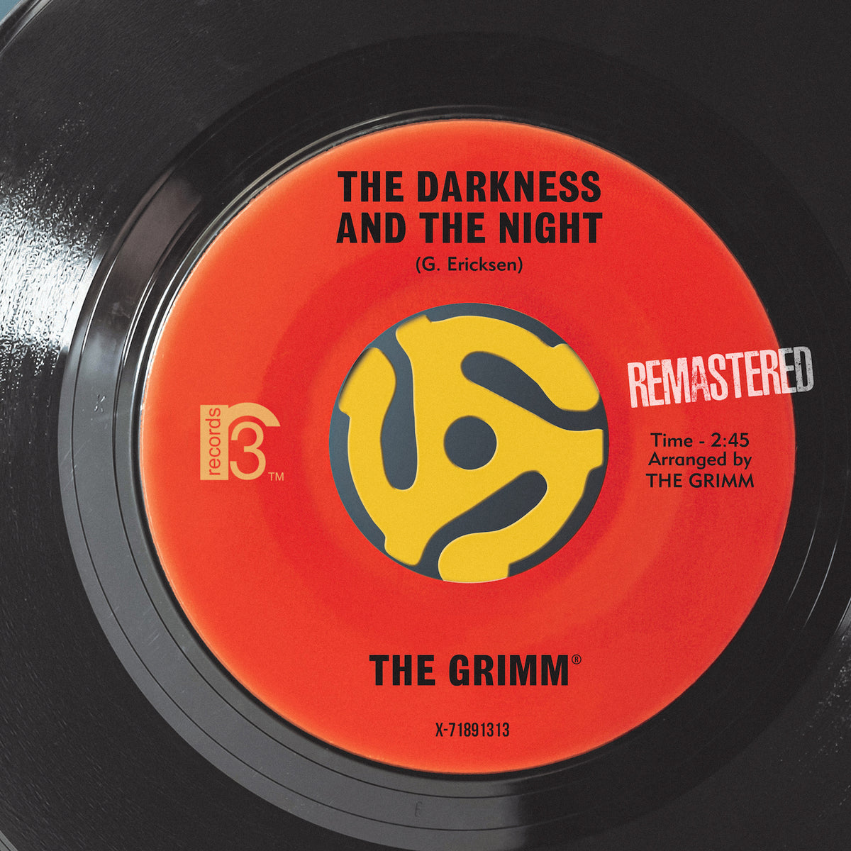 A close-up of a vinyl record label showing the text 'THE DARKNESS AND THE NIGHT', indicating the name of a song and an arranged by credit to 'THE GRIMM'. There is a 'REMMASTERED' stamp on the label, and the record company's name 'MCA' is visible.